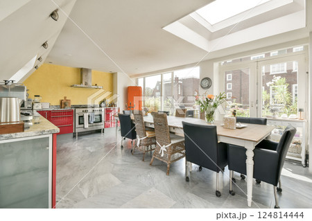 A stylish modern kitchen featuring a spacious dining area, large windows allowing natural light, and contemporary decor in a vibrant setting. A stylish modern kitchen featuring a spacious dining area, large windows allowing natural light, and contemporary decor in a vibrant setting. 124814444