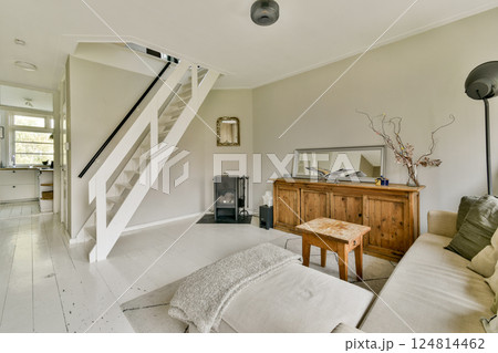 A stylish living room featuring a cozy sofa, elegant wooden furniture, and a blend of natural light that enhances the minimalist decor. A stylish living room featuring a cozy sofa, elegant wooden furniture, and a blend of natural light that enhances the minimalist decor. 124814462