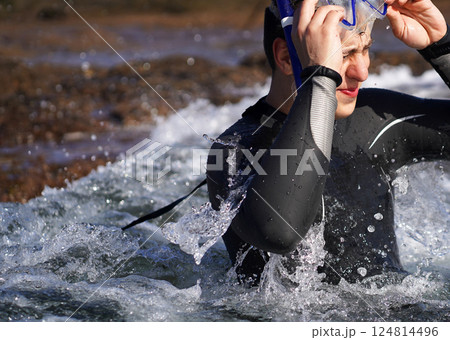 A man leads an active lifestyle, swims with a mask and a snorkel in the ocean. 124814496