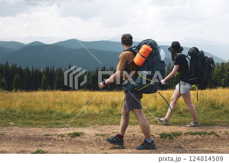 Two people are hiking with backpacks in the mountains. Two people are hiking with backpacks in the mountains. 124814509