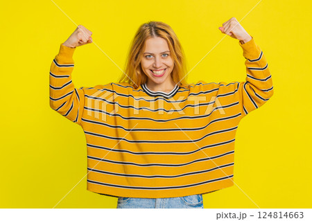 Happy woman looking confident showing biceps feeling power strength to fight for rights success win 124814663