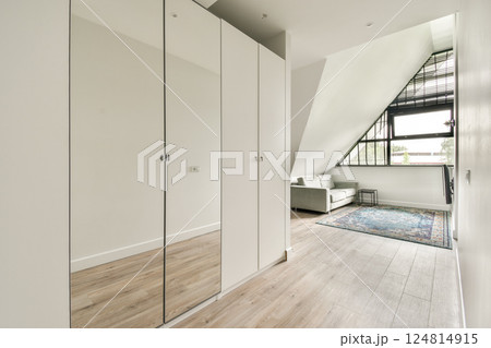 A stylish interior featuring sleek cabinets, elegant furniture, and a vibrant rug in a well-lit room with modern architectural elements. A stylish interior featuring sleek cabinets, elegant furniture, and a vibrant rug in a well-lit room with modern architectural elements. 124814915