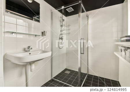 A contemporary shower room featuring a sleek glass enclosure and minimalistic design elements, perfect for a refreshing bathing experience. 124814995