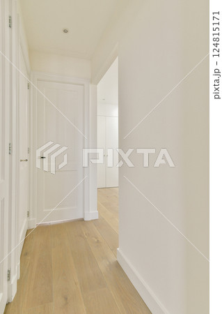 This interior features a sleek, minimalist hallway with white walls, a wooden floor, and clean lines, creating a serene atmosphere. 124815171