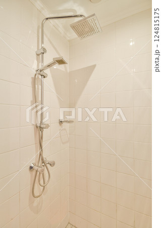 A sleek and contemporary shower area featuring minimalist design elements, clean tiles, and a stylish shower fixture setup. 124815175