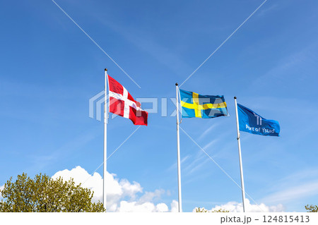Denmark and Sweden flags and the flag of the port of the city of Ystad against blue sky Denmark and Sweden flags and the flag of the port of the city of Ystad against blue sky 124815413