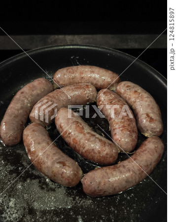 Sizzling bratwurst glistening with golden oil, nestled in cast iron skillet, rustic french alpine cuisine in chamonix Sizzling bratwurst glistening with golden oil, nestled in cast iron skillet, rustic french alpine cuisine in chamonix 124815897