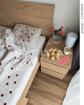 Romantic bedroom morning with heart bedding, fresh croissants, roses, coffee for valentine's breakfast surprise Romantic bedroom morning with heart bedding, fresh croissants, roses, coffee for valentine's breakfast surprise 124816045