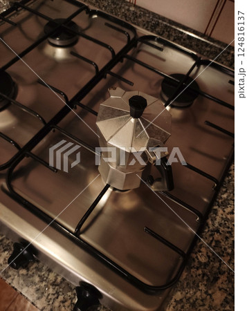 Classic aluminum moka pot brewing traditional espresso on rusty gas stove, italian kitchen setting in bibione Classic aluminum moka pot brewing traditional espresso on rusty gas stove, italian kitchen setting in bibione 124816137