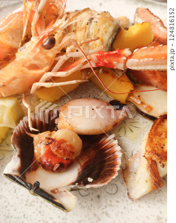 Close up of a delectable seafood platter featuring grilled prawns, scallops, and lemon wedges, showcasing italian culinary artistry in bibione, italy Close up of a delectable seafood platter featuring grilled prawns, scallops, and lemon wedges, showcasing italian culinary artistry in bibione, italy 124816152