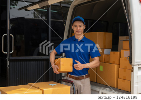 Asian delivery man portrait of young man holding cardboard box while unloading moving van outdoors. Asian delivery man portrait of young man holding cardboard box while unloading moving van outdoors. 124816199