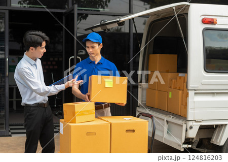 Asian man signs for parcel delivery, confirming shipment. Concept of e-commerce, logistics, and fast courier service for secure package handling. Asian man signs for parcel delivery, confirming shipment. Concept of e-commerce, logistics, and fast courier service for secure package handling. 124816203