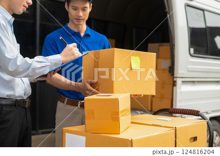 Asian man signs for parcel delivery, confirming shipment. Concept of e-commerce, logistics, and fast courier service for secure package handling. 124816204
