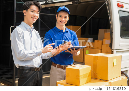 Asian man signs for parcel delivery, confirming shipment. Concept of e-commerce, logistics, and fast courier service for secure package handling. Asian man signs for parcel delivery, confirming shipment. Concept of e-commerce, logistics, and fast courier service for secure package handling. 124816210