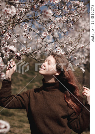 Young woman enjoying spring blossom almond tree in prague, petrin gardens Young woman enjoying spring blossom almond tree in prague, petrin gardens 124816278