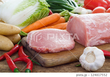 Vegetables and pork meat on cutting board Vegetables and pork meat on cutting board 124817552