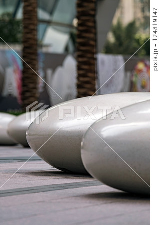Seats in the shape of smooth large stones in a public park. 124819147