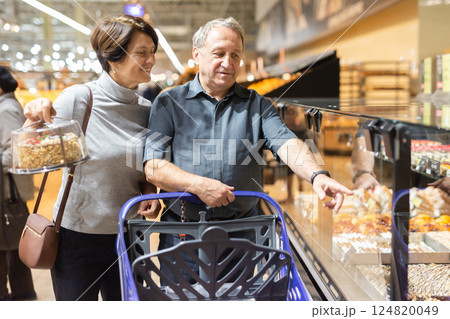 Married couple choose groceries together in supermarket 124820049