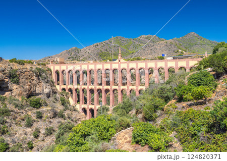 Aguila aqueduct, bridge near The Nerja seaside town of The Costa del Sol coastline in Andalusia. Ancient aqueduct spans a valley, showcasing impressive architecture against a backdrop of mountains. Aguila aqueduct, bridge near The Nerja seaside town of The Costa del Sol coastline in Andalusia. Ancient aqueduct spans a valley, showcasing impressive architecture against a backdrop of mountains. 124820371