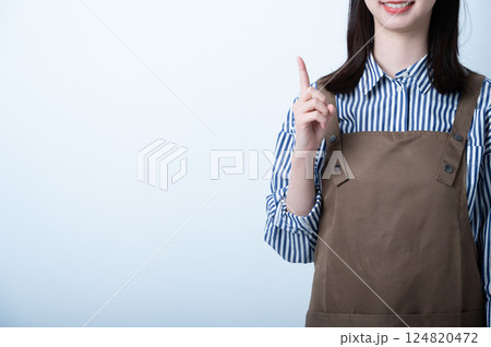 指を立てるエプロンの女性 124820472