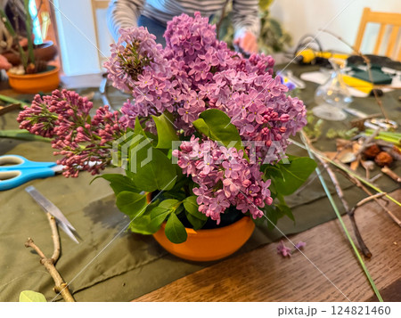 Lilac arrangement in progress on creative workspace. Natural beauty, floral art and mindfulness through ikebana composition Lilac arrangement in progress on creative workspace. Natural beauty, floral art and mindfulness through ikebana composition 124821460