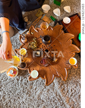 A woman prepares loose leaf tea during a traditional tea ceremony with friends. Community, mindfulness and the ritual of sharing tea 124821483