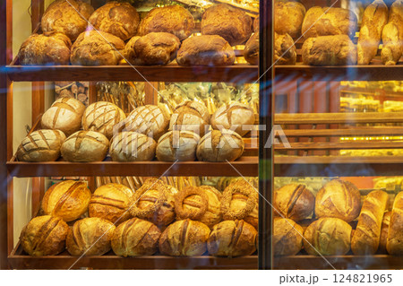 Fresh artisan bread in bakery display with golden crust and warm light. Bread display reflects comfort, tradition, daily food delight 124821965