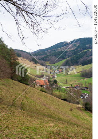 Rolling green hills cradle quaint villages under a cloudy sky in a tranquil landscape of Germany's countryside during early springtime Rolling green hills cradle quaint villages under a cloudy sky in a tranquil landscape of Germany's countryside during early springtime 124822030