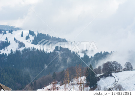Winter serenity envelops picturesque mountain landscape during a cloudy day in the heart of nature, showcasing vast snow-covered hills and evergreen trees Winter serenity envelops picturesque mountain landscape during a cloudy day in the heart of nature, showcasing vast snow-covered hills and evergreen trees 124822081