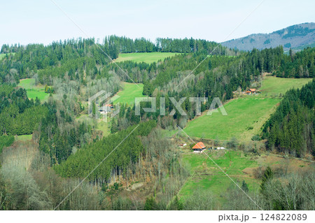 Rolling green hills and rural charm blend harmoniously in a serene landscape showcasing the beauty of nature in early spring near a quaint farmhouse 124822089