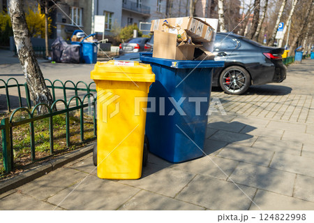 Yellow and blue trash bins placed on the street for waste separation 124822998