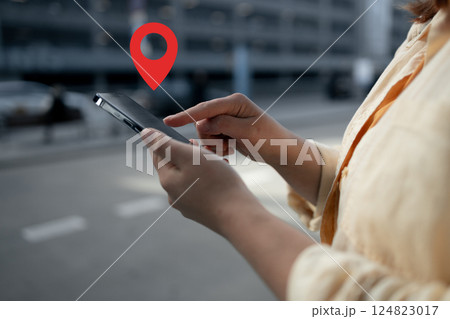 Woman using smartphone with location pin symbol Woman using smartphone with location pin symbol 124823017