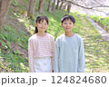 春の公園に立つ小学生男女 124824680