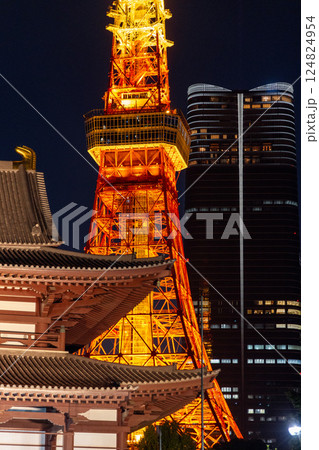 Close-up night view of Tokyo Tower glowing in golden light beside the wooden roof of Zojo-ji Temple Close-up night view of Tokyo Tower glowing in golden light beside the wooden roof of Zojo-ji Temple 124824954