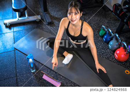 タブレットでYouTube動画を見ながらジムでストレッチするかっこいい女性 やり方 動画視聴 俯瞰 タブレットでYouTube動画を見ながらジムでストレッチするかっこいい女性 やり方 動画視聴 俯瞰 124824988