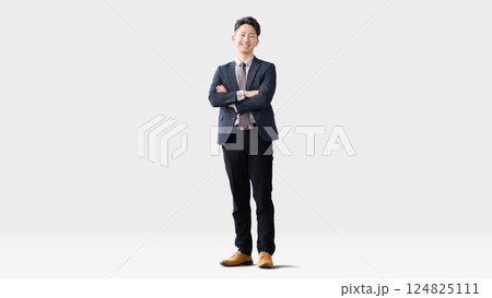 腕組みをして立つ笑顔の男性ビジネスマン 124825111