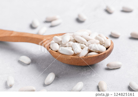 Navy beans on wooden spoon, close up 124825161