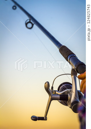 A fisherman with a fishing rod 124825743