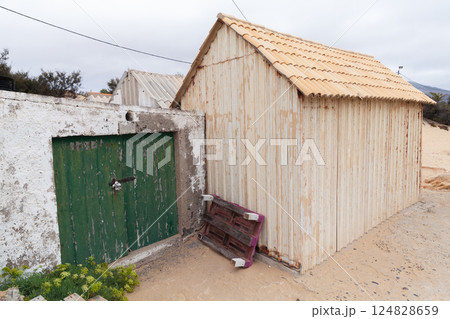 Weathered coastal barns with green-painted wooden door 124828659
