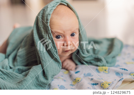 One-month-old baby lying on tummy and curiously observing surroundings. Infant tummy time for neck strength, cognitive development, and early exploration. Parenting and newborn growth concept 124829675