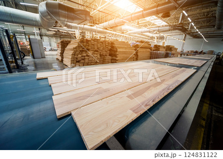 Production line of the wooden floor factory. CNC automatic woodworking machine. Production line of the wooden floor factory. CNC automatic woodworking machine. 124831122
