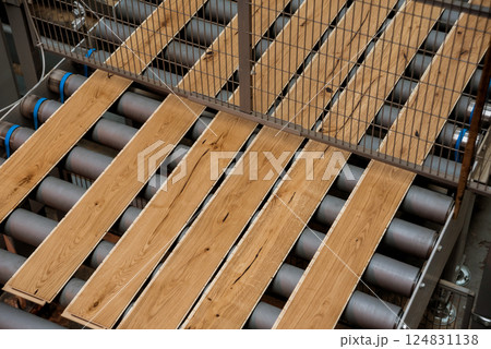Production line of the wooden floor factory. CNC automatic woodworking machine. 124831138