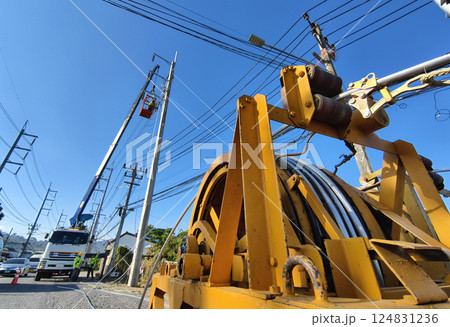 Installation of high-voltage electric wires on new poles along the road 124831236