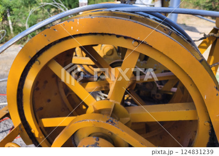 A large wooden spool of high-voltage electric wires is located on the road A large wooden spool of high-voltage electric wires is located on the road 124831239