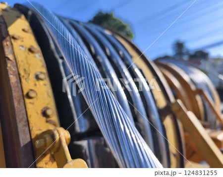 A large wooden spool of high-voltage electric wires is located on the road A large wooden spool of high-voltage electric wires is located on the road 124831255