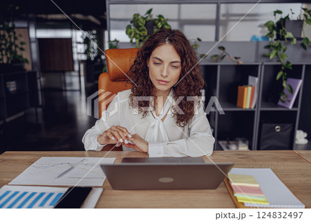 A Focused and Dedicated Professional Engaged in Working on a Laptop in a Modern Office Environment 124832497