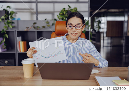 A skilled and professional woman is giving a presentation of data in a modern office environment 124832500
