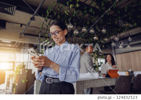 A Professional Woman Actively Engaged in Her Work Within a Contemporary Office Setting A Professional Woman Actively Engaged in Her Work Within a Contemporary Office Setting 124832523