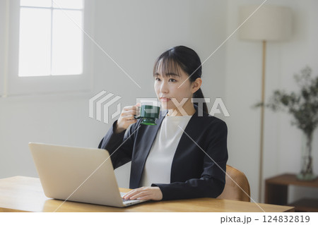 仕事中にコーヒーを飲む女性  124832819