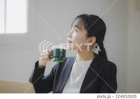 仕事中にコーヒーを飲む女性  124832820